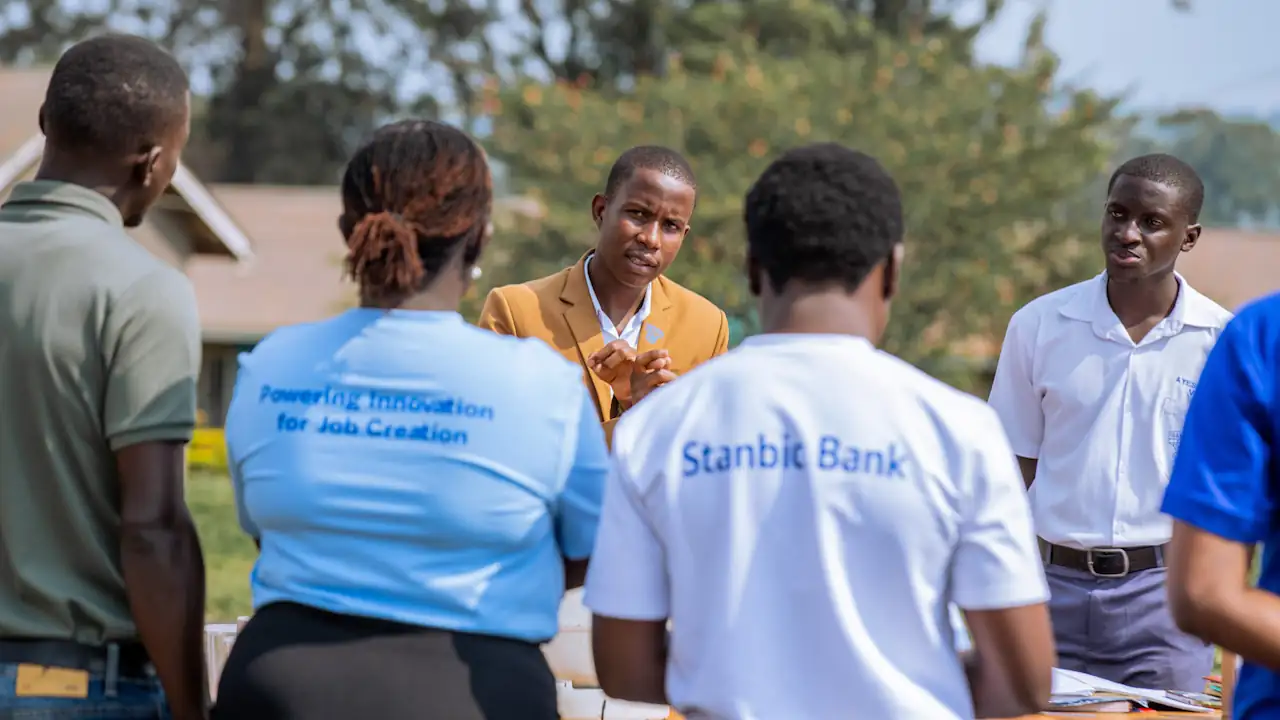 A student explains their prototype to the Stanbic NSC implementation team during an appraisal visit earlier this week. The implementation team, from Stanbic Bank Uganda, have their backs to the camera
