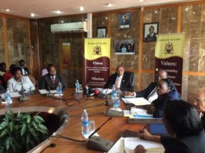 Officials seated around a conference table during a press briefing