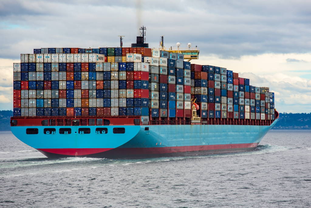 Blue and red cargo ship on sea during daytime