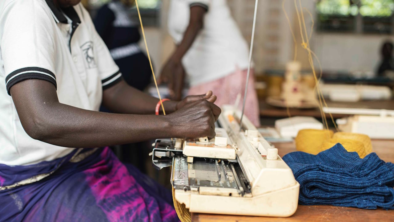 Woman using a knitting machine in northern Uganda