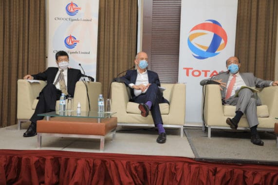 Three male executives at a press conference