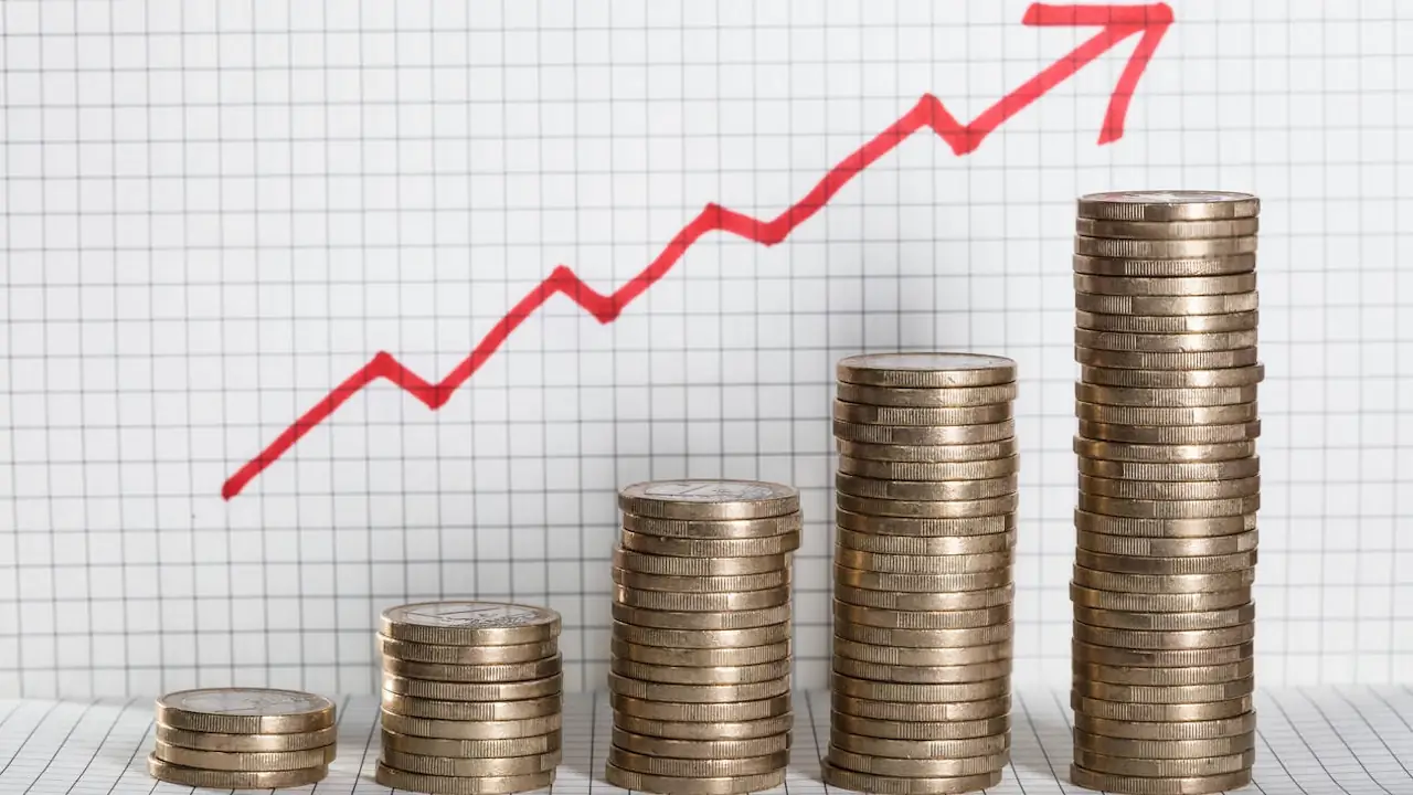 Increasing piles of coins with a red arrow on a square patterned background.