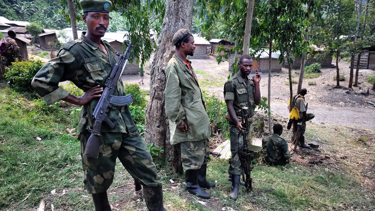 Five men wearing combat fatigues and carrying guns