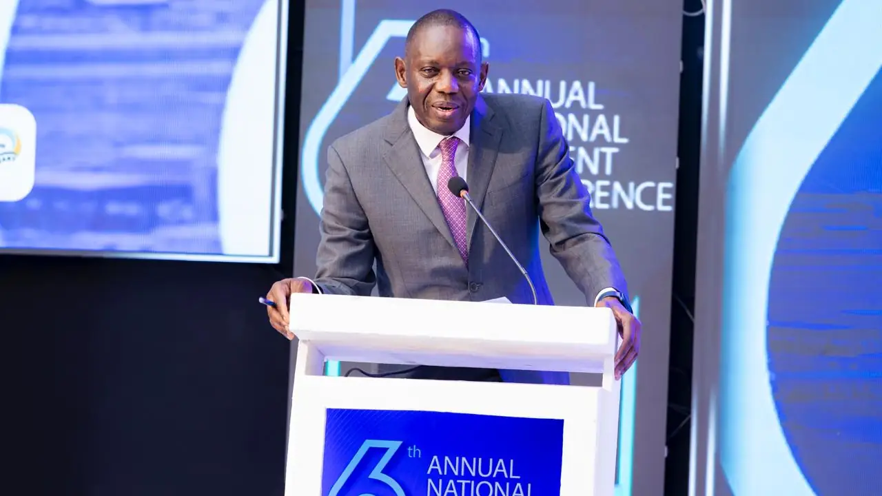 A man in a business suit delivers a speech from behind a lectern.