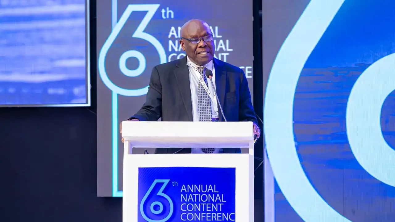 A man in a business suit delivers a speech from behind a lectern.