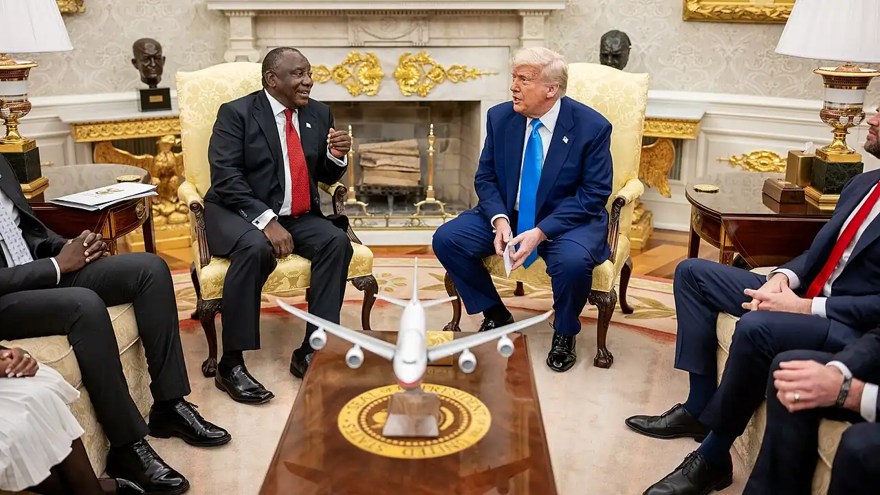 President Donald Trump meets with President Cyril Ramaphosa of South Africa in the Oval Office. They are flanked by officials from both the United States and South Africa.
