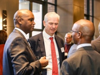 Three businessmen in an informal exchange at a business forum