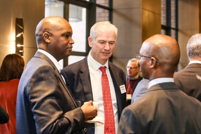 Three businessmen in an informal exchange at a business forum