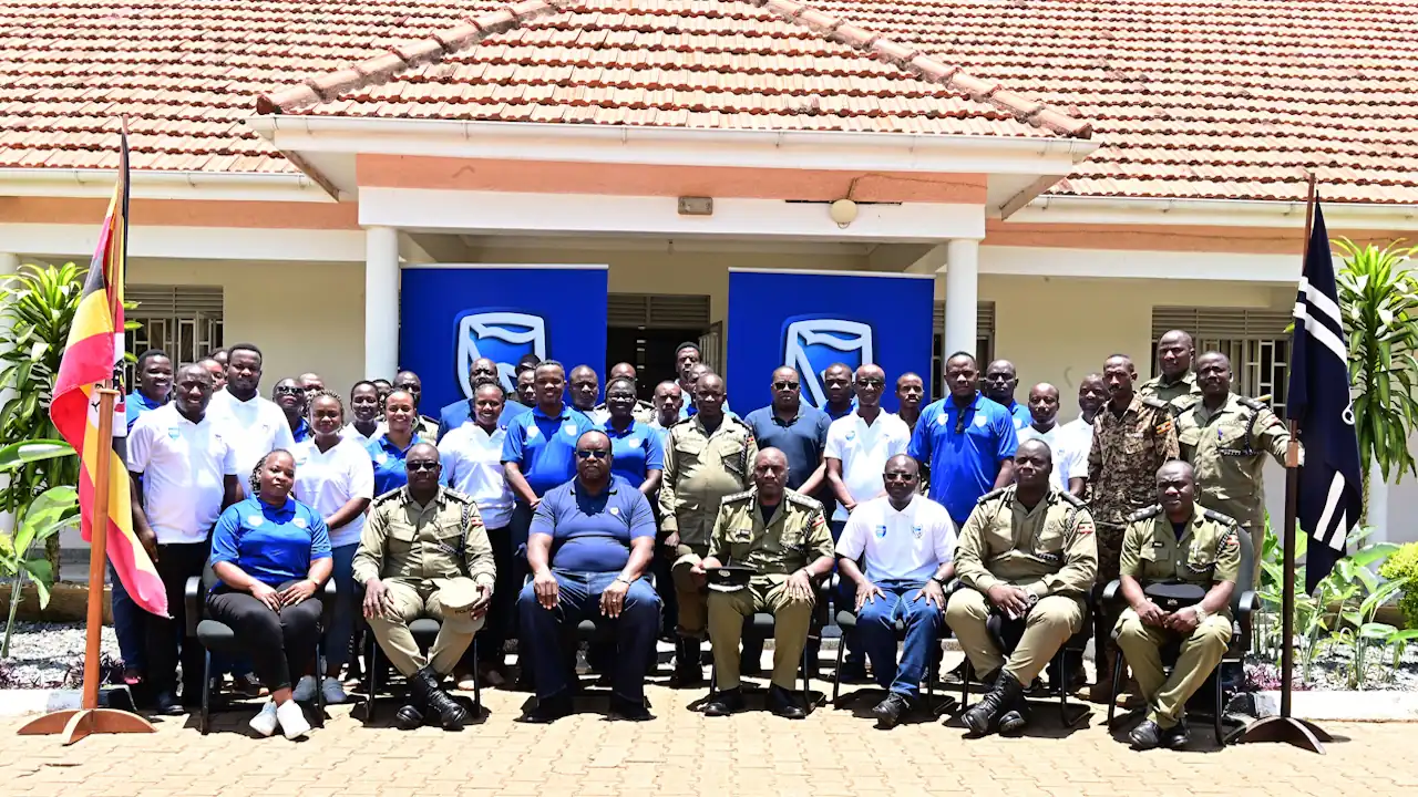 Delegations from Stanbic Bank Uganda and the Uganda Police Force pose for a group photograph in front of the Kabalye Police Training School during the official handover of solar-powered lighting equipment.