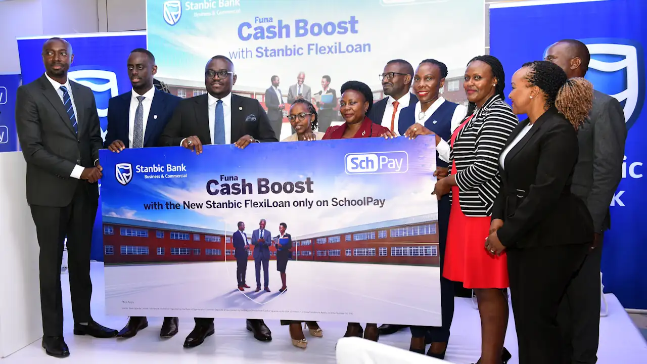 Officials from Stanbic Bank Uganda, FinCom Technologies, and the Ministry of Education hold a branded banner announcing the Stanbic FlexiLoan partnership with SchoolPay at a launch event in Kampala.