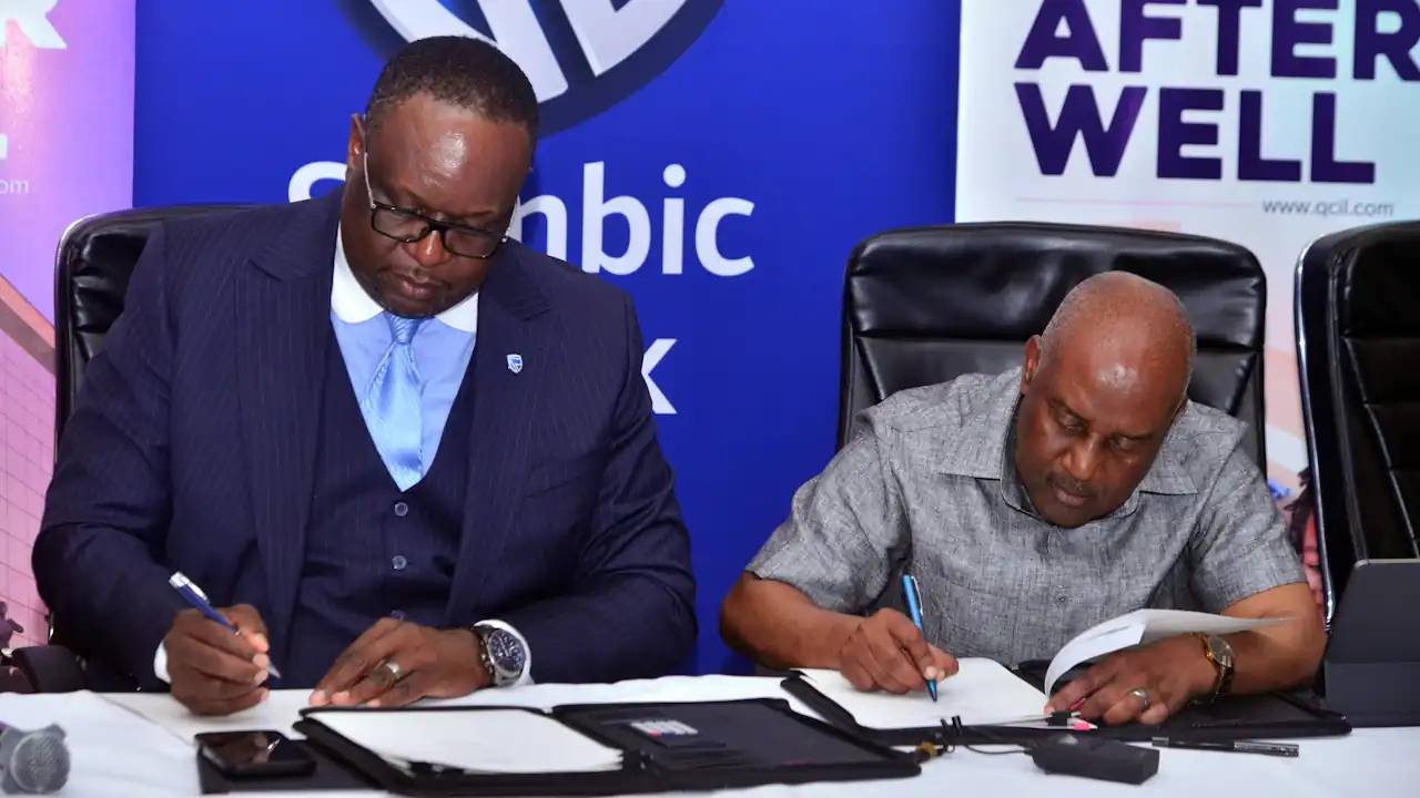 Two men signing a host of financing documents
