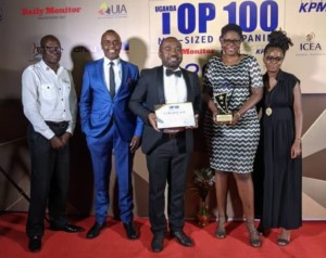 A group of five people posing with a certificate and a trophy at a gala dinner