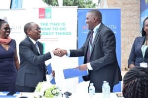 The Medical Concierge Group MD Davis Musinguzi and UAP Old Mutual Uganda MD Stephen Chikovore shake hands