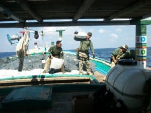 US Navy mencarry bags containing Hashish captured from a dhow in the Arabian Sea, March 17, 2017