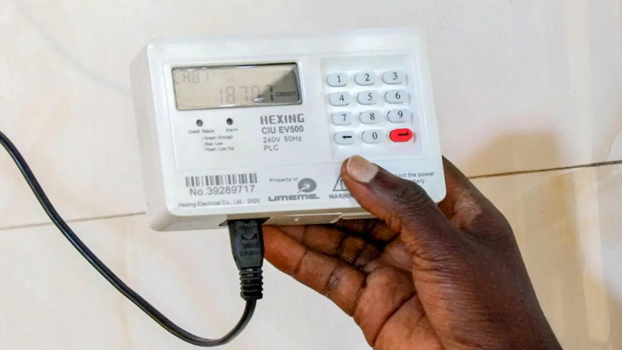 A hand holding a Umeme 'Hexing' to the camera. The distributor uses both Hexing and Conlog for its metres.