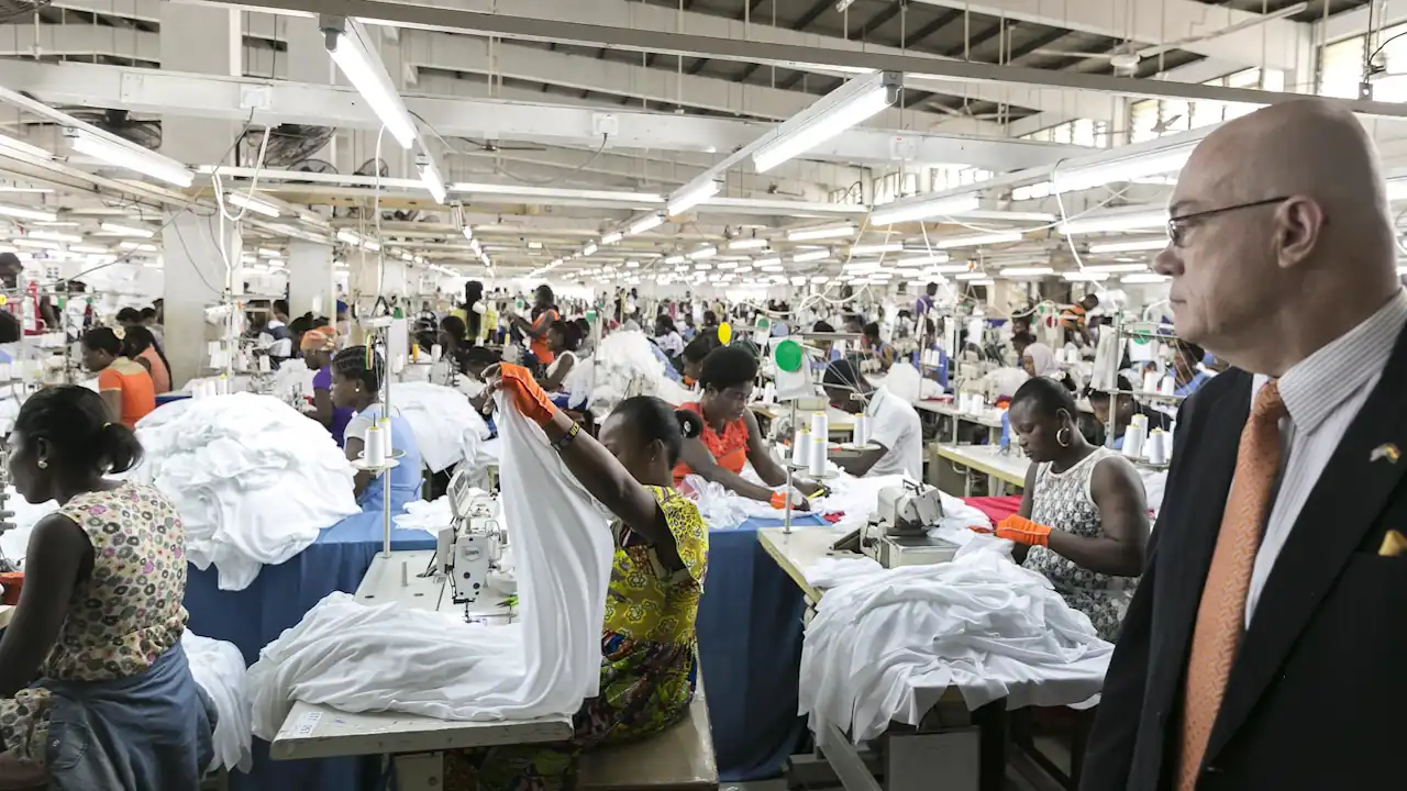 The interior of the Dignity DTRT apparel plant shows rows of workers at sewing stations during a visit from American diplomats.