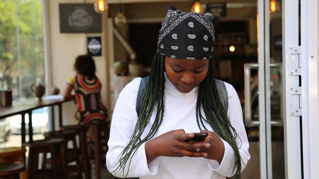 Young woman typing on a smartphone