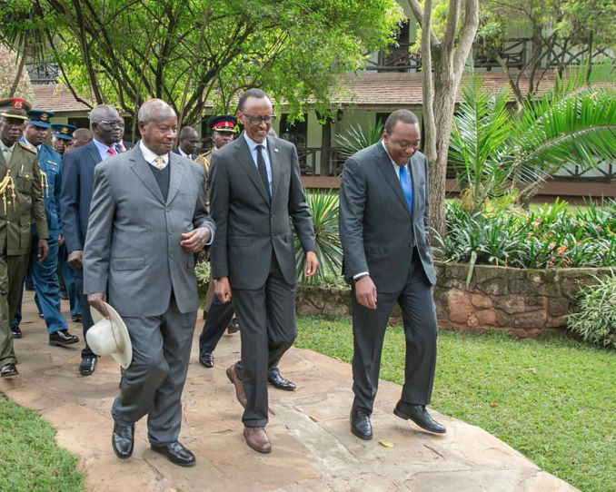 Presidents Yoweri Museveni, Paul Kagame, and Uhuru Kenyatta walking on a pathway in Nairobi