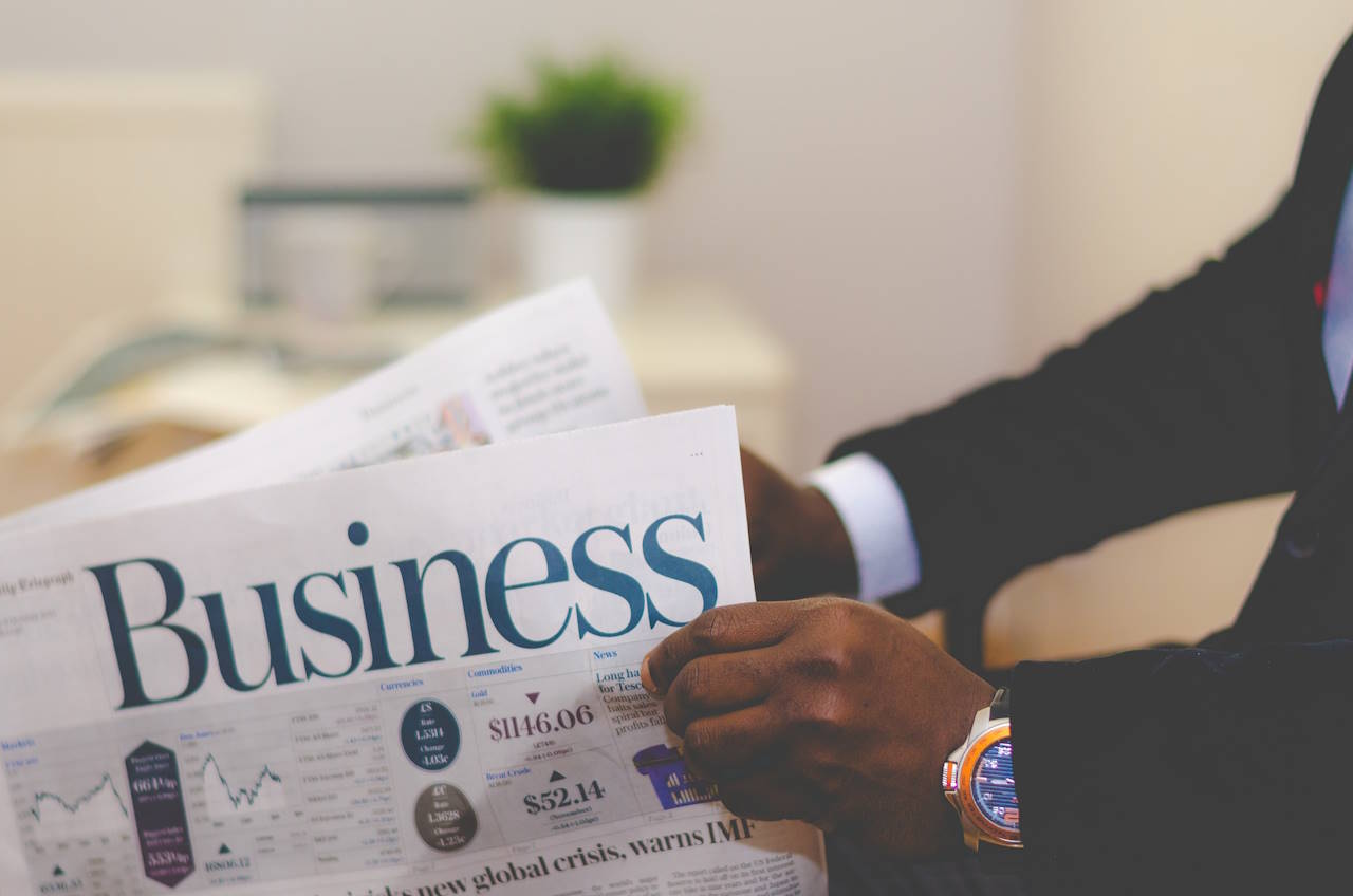 A dandy businessperson, opening a newspaper